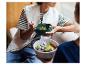 Twee mensen eten salades uit kommen, één met een vork.