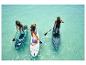 Drie personen suppen op turquoise water. Opblaasbare SUP boards zijn zichtbaar.