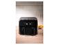 Een moderne, zwarte airfryer op een houten aanrecht.