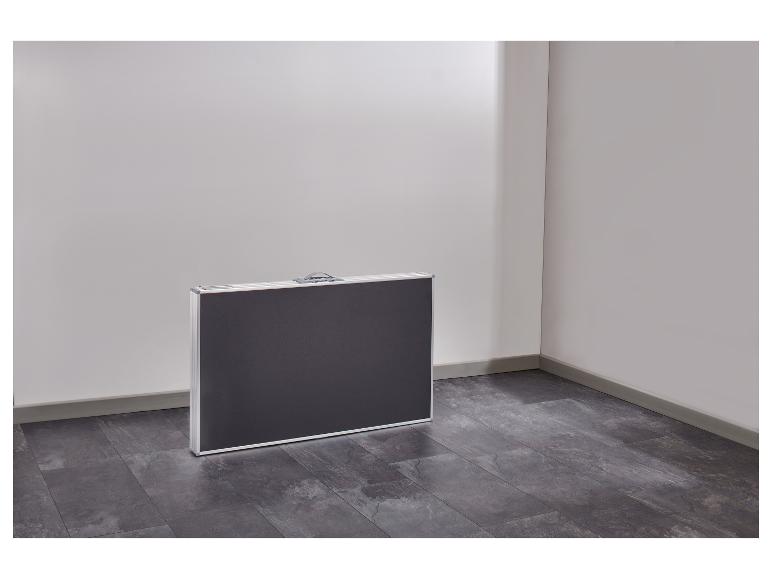 Opvouwbare campingtafel in een hoek van een kamer met donkere vloer