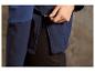 Gros plan d'une veste softshell bleu foncé avec une fermeture éclair verte.