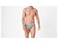 Homme torse nu en slip gris sur fond blanc.