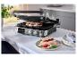 Grill met twee sandwiches, tomaten, mozzarella en basilicum op een witte tafel.