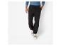 Man draagt zwarte broek met trekkoord en beige sneakers.