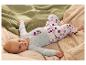 Baby in lichtblauw rompertje met strikjes en stippenbroek, liggend op dekens.