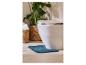 Wit toilet met een blauwe badmat, plant en gevlochten manden met toiletpapier.
