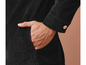 Een close-up van een zwarte corduroy jas met een hand in de zak.