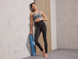 Vrouw in sportkleding met een yogamat