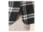Chemise à carreaux noire et blanche avec ourlet arrondi, associée à un pantalon clair.