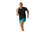 Man in zwarte T-shirt en turquoise shorts aan het rennen.