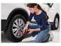 Une femme utilise un gonfleur Ultimate pour pneus de voiture.