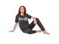 Femme en pyjama Stitch gris foncé, assise par terre.