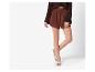 Bruine shorts en trui, beige sandalen.