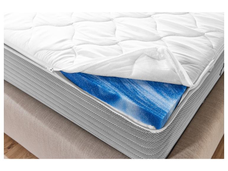 Un matelas blanc avec un matelas en gel bleu en dessous