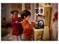 Twee kinderen spelen in een speelkeuken met een oven en een gootsteen.