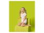 Fille en pyjama à cœurs assise sur un fauteuil vert.