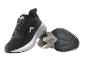 Zwarte sportschoenen met wit-grijze zool, naast elkaar liggend.