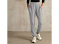Pantalon de survêtement gris et baskets blanches.
