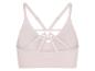 Brassière de sport rose clair avec bretelles croisées au dos.
