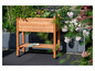 Een houten plantenbak met bloemen en een paar tuinhandschoenen.