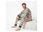 Homme en pyjama de Noël beige avec des motifs rouges et verts assis sur un banc blanc.