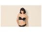 Femme en soutien-gorge bandeau noir et culotte noire, posant devant un fond clair.