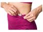Femme mettant une clé dans la poche cachée de son legging de sport magenta.