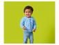 Bébé souriant portant un cardigan en maille bleu et un jean.