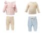Babykledingsets: roze top met ruches, beige geribbelde top, beige leggings en lichtblauwe shorts.