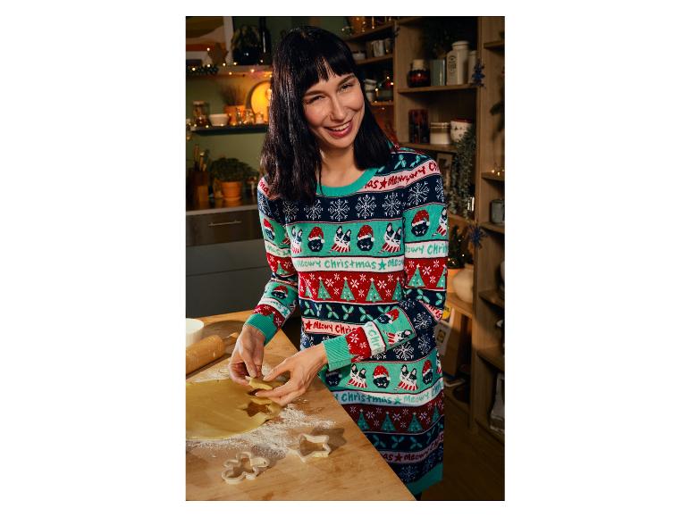 Een vrouw in een kersttrui bakt kerstkoekjes.