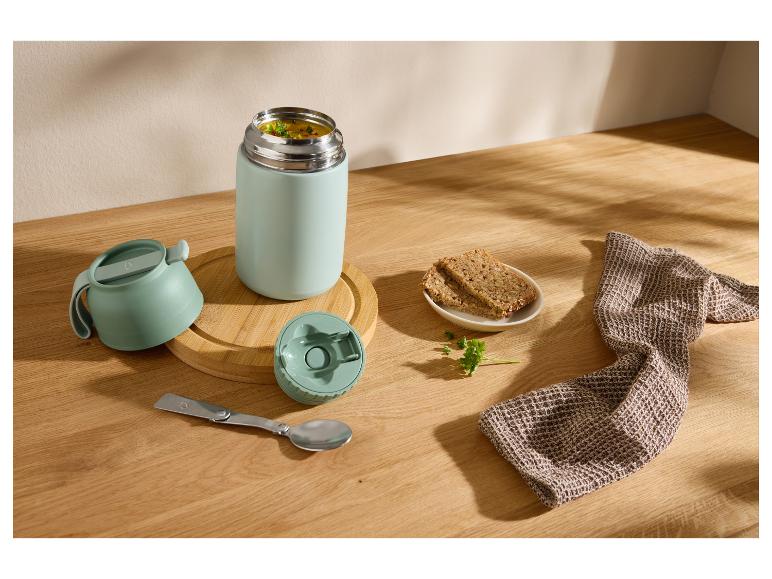 Thermosfles met soep, brood en opvouwbare lepel op een houten tafel.