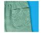Close-up van een groene joggingbroek met achterzak op een blauwe achtergrond.