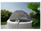 Opblaasbare jacuzzi met overkapping, twee drankjes en groene tuinachtergrond.