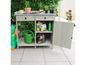 Tuinwerkbank met laden, kast en een gieter.