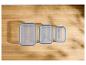 Trois boîtes alimentaires rectangulaires avec couvercles bleus sur une table en bois.