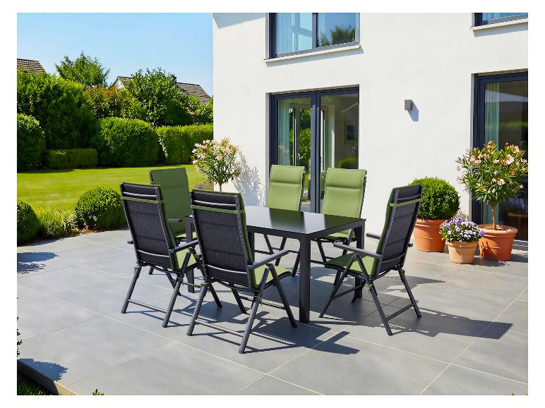 Tuinmeubelset met zwarte tafel en groene stoelen op een terras.
