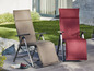 Deux chaises longues de jardin, beige et rouge, avec des appuie-têtes.