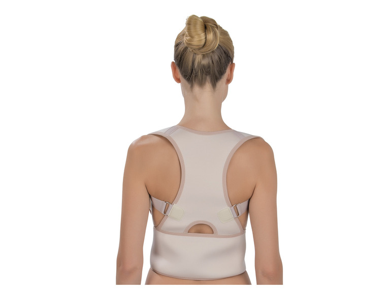 Une femme porte un correcteur de posture beige.