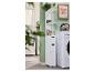 Badkamer met wasmachine, witte kast met lades en planken, en een ingelijste afbeelding.