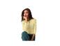 Vrouw in geel shirt met lange mouwen en groene broek, zittend en wegkijkend.