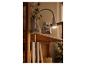 Witte klemlamp verlicht een houten plank met decoratie.