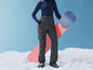Een vrouw in wintersportkleding met een snowboard.