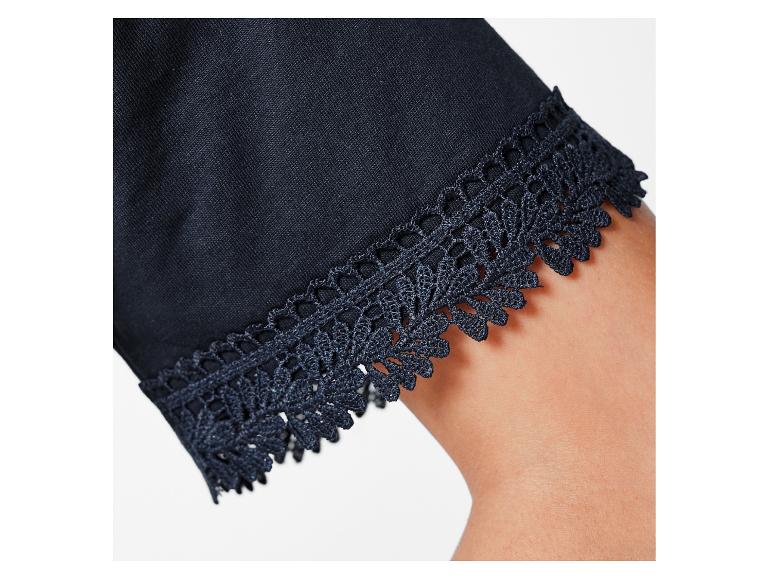 Detail van een donkerblauwe top met kant.
