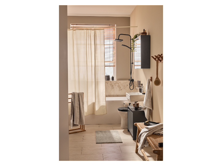 Een moderne badkamer met douche, wastafel en bad in lichte, neutrale tinten.