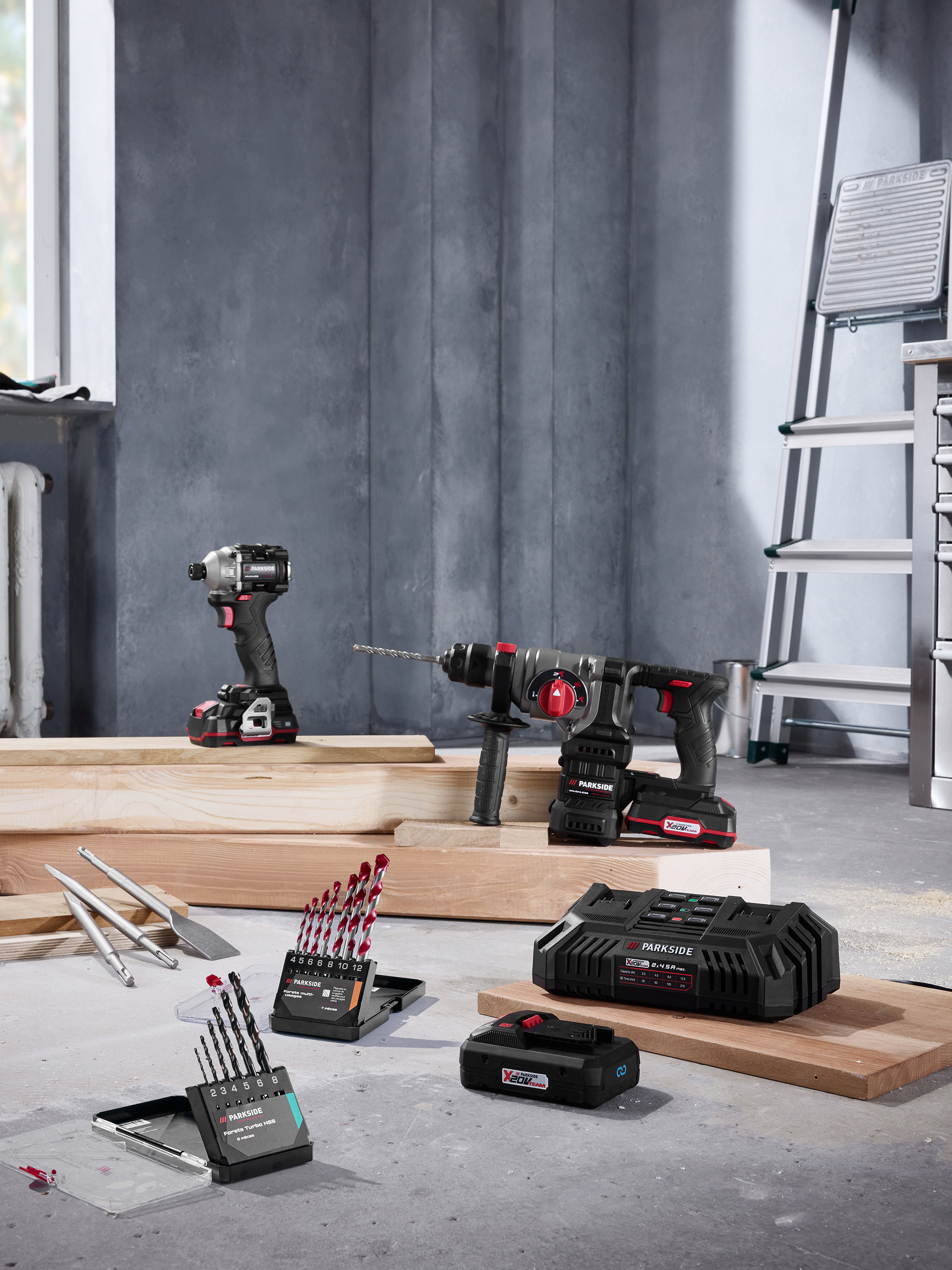 Outils électriques Parkside avec perceuses, forets et chargeur dans un environnement de chantier.
