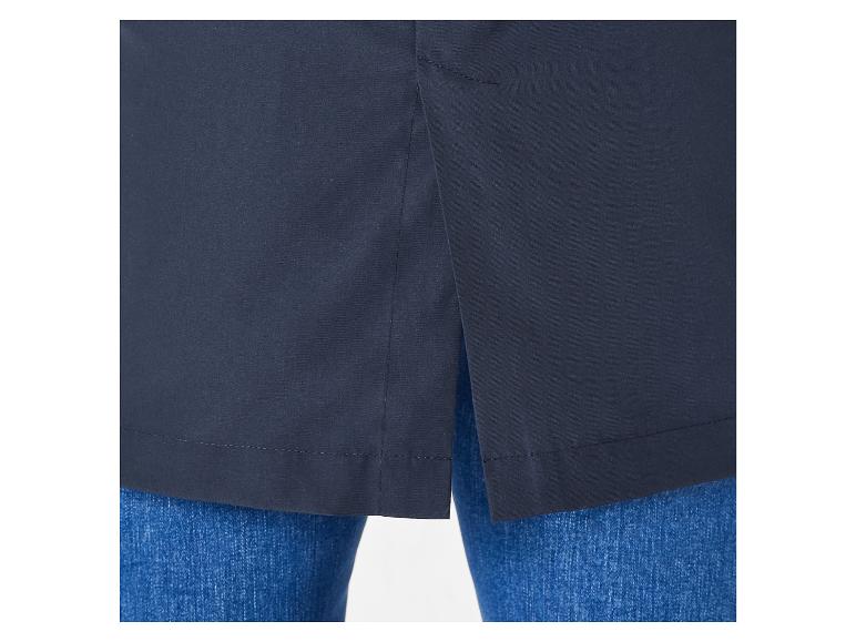 L'ourlet d'une veste bleu marine, portée avec un jean bleu.