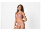 Femme portant une brassière et une culotte en dentelle rose clair.