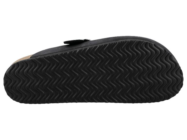 Vue de dessous d'une sandale noire avec une semelle texturée ondulée.