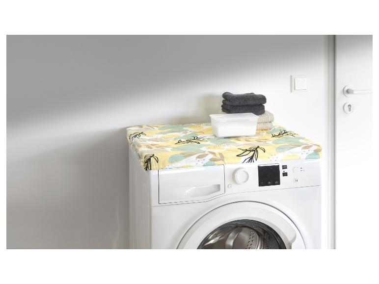 Machine à laver avec un housse à motifs et des serviettes.