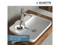 Un lavabo blanc avec un robinet chromé et un drain pop-up.